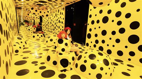 A Yayoi Kusama robot is painting the windows of the Louis 